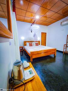 a room with a bed and a pot on a table w obiekcie Sunbird's Home w mieście Udawalawe