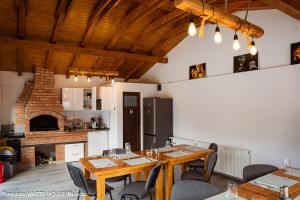 a dining room with tables and chairs and a fireplace at White House Moieciu in Moieciu de Jos