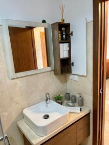 La salle de bains est pourvue d'un lavabo blanc et d'un miroir. dans l'établissement Cozy Panoramic Charming studio with sunny terrace, à Marrakech