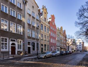 a street with cars parked in front of buildings at Old Town Studio with Mezzanine in Gdańsk