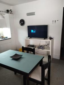 a dining room with a table and a tv at Altos Penitentes Lomas Blancas, dúplex in Uspallata