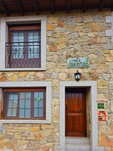 un edificio de piedra con 2 ventanas y una puerta en El Cerrillo 1, en San Martín del Pimpollar
