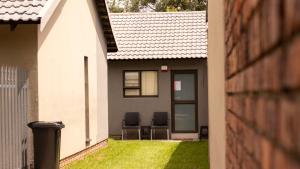 two chairs sitting in the back yard of a house at Leipoldt Self-Catering Apartment in Secunda