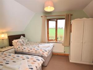 1 dormitorio con 2 camas y ventana en 3 Bed in Ledbury 77378 