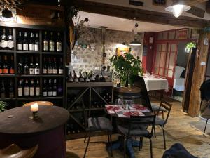 un restaurante con 2 mesas y botellas de vino en COSY B&B en Murat