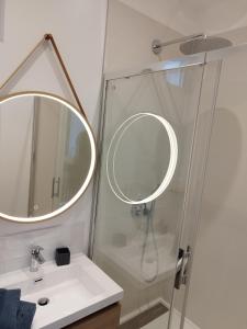 ein Bad mit einer Dusche, einem Waschbecken und einem Spiegel in der Unterkunft ROMANESCO in Rennes