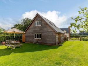 Casa de madera con mesa de picnic y sombrilla en 1 Bed in Hereford 83703, en Wormbridge