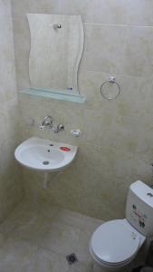 a bathroom with a sink and a toilet and a mirror at Семеен хотел Узана in Gabrovo