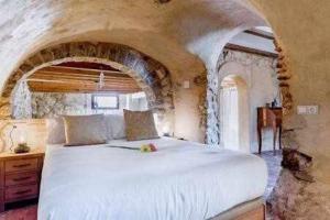 um quarto com uma grande cama branca numa parede de pedra em Altea Suite Vault Casa autentica del Casco antiguo by Vero em Altea