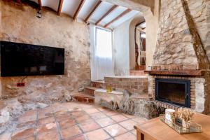uma sala de estar com uma lareira de pedra e uma televisão em Altea Suite Vault Casa autentica del Casco antiguo by Vero em Altea