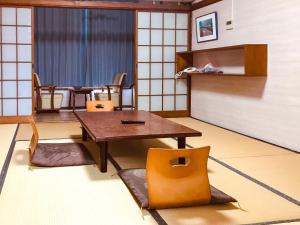 uma sala de jantar com uma mesa e cadeiras num quarto em Eimiya Ryokan - Vacation STAY 36263v em Amakusa