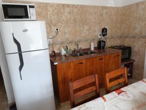 een keuken met een witte koelkast en een spoelbak bij Las Madreselvas in Villa de la Quebrada