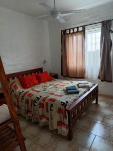 een slaapkamer met een groot bed met rode kussens bij Las Madreselvas in Villa de la Quebrada