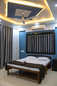 Sukhakarta Holiday Home في Veshvi: سرير في غرفة ذات جدار ازرق