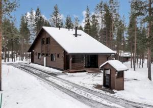 uma pequena cabana de madeira com neve em Paritalomökki Välirakka em Kittilä