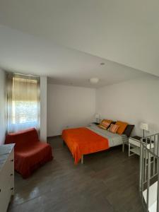 a bedroom with a bed with an orange blanket at El Cortijo Bungallows in Playa de las Americas