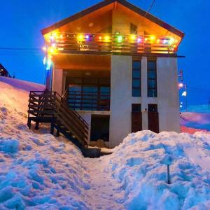 a house with lights on top of a pile of snow at Cottage in Gudauri in Gudauri