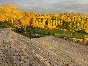 a large wooden deck with a view of a garden at Perma Ridge Farmstay in Ngaruawahia