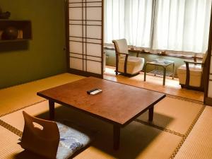 uma sala de estar com uma mesa de centro e uma cadeira em Eimiya Ryokan - Vacation STAY 36252v em Amakusa