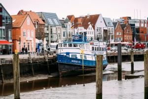 a blue and white boat is docked at a marina at Tor zur Altstadt in Husum