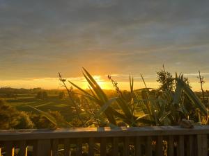 a view of the sunset from a deck at Perma Ridge Farmstay in Ngaruawahia