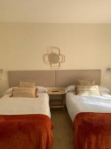 dos camas sentadas una al lado de la otra en una habitación en Pensión Cantabrico en Navia