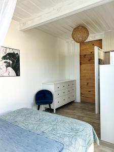 um quarto com uma cama e uma cadeira azul em Villa Monica, maison idéale avec enfants em Saint-François