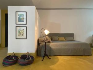 1 dormitorio con 1 cama con 2 cestas y 1 lámpara en Esquina do Visconde, Guesthouse, en Torre de Moncorvo