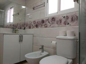 baño con aseo y lavabo y ventana en Beach and sun guest house en Torrevieja