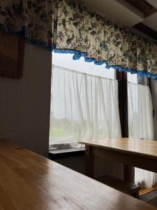 a room with two tables and a window with curtains at Готельно-Ресторанний комплекс Кичера in Volovets