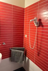 y baño con pared roja y ducha. en AR GOLDEN HOUSE en Košice