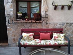 a red bench with pillows sitting in front of a window at Zohet Santian in Arcones