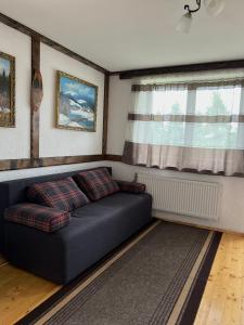 um sofá numa sala de estar com uma janela em Готельно-Ресторанний комплекс Кичера em Volovets