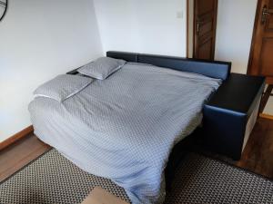 a bedroom with a bed and a black chair at Studio spacieux tout équipé avec jardin in Varennes Vauzelles