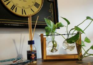 a clock and two vases and a bottle on a table at Casa vacanze Santa Marta in Barletta