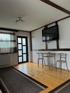 a room with a table and two chairs and a flat screen tv at Готельно-Ресторанний комплекс Кичера in Volovets