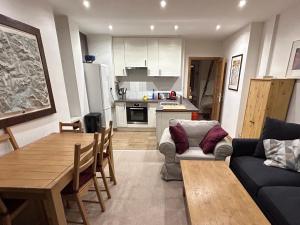 a living room with a couch and a table and a kitchen at Le Portillo in Val dʼIsère