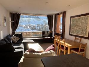 a living room with a couch and a table at Le Portillo in Val dʼIsère