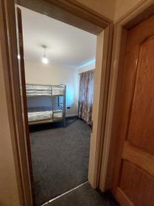 a hallway with a bedroom with a bunk bed at Dobcross Close in Manchester
