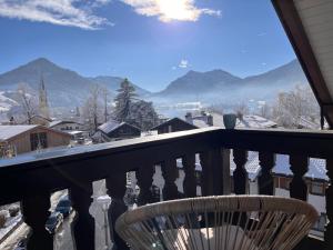 een stoel op een balkon met uitzicht op de bergen bij Ferienwohnung Inselblick in Schliersee