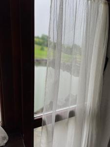 okno z białą zasłoną w pokoju w obiekcie Готельно-Ресторанний комплекс Кичера w mieście Wołowiec