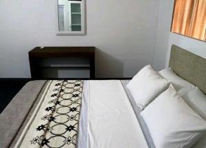 Schlafzimmer mit einem Bett mit einem Tisch und einem Spiegel in der Unterkunft Rochana Holiday Resort in Anuradhapura