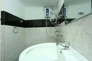 ein Bad mit einem Waschbecken und einem Spiegel in der Unterkunft Rochana Holiday Resort in Anuradhapura