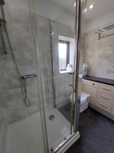 a bathroom with a glass shower with a toilet at Dobcross Close in Manchester