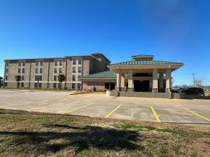 a parking lot in front of a large building at Super 8 by Wyndham Alexandria LA in Alexandria