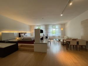 Hotel Kieler Yacht-Club في كيل: غرفة معيشة مع سرير وغرفة طعام
