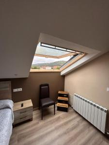 a bedroom with a window and a bed and a chair at Hotel Restaurante el Fornon in Novellana
