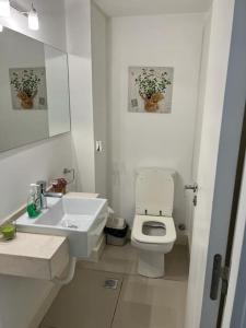bagno bianco con lavandino e servizi igienici di Edificio Unique a Punta del Este