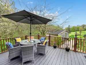 a table with chairs and an umbrella on a deck at 3 bed property in Bude 29125 in Thornbury