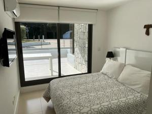 1 dormitorio con cama y vistas a la piscina en Edificio Unique en Punta del Este